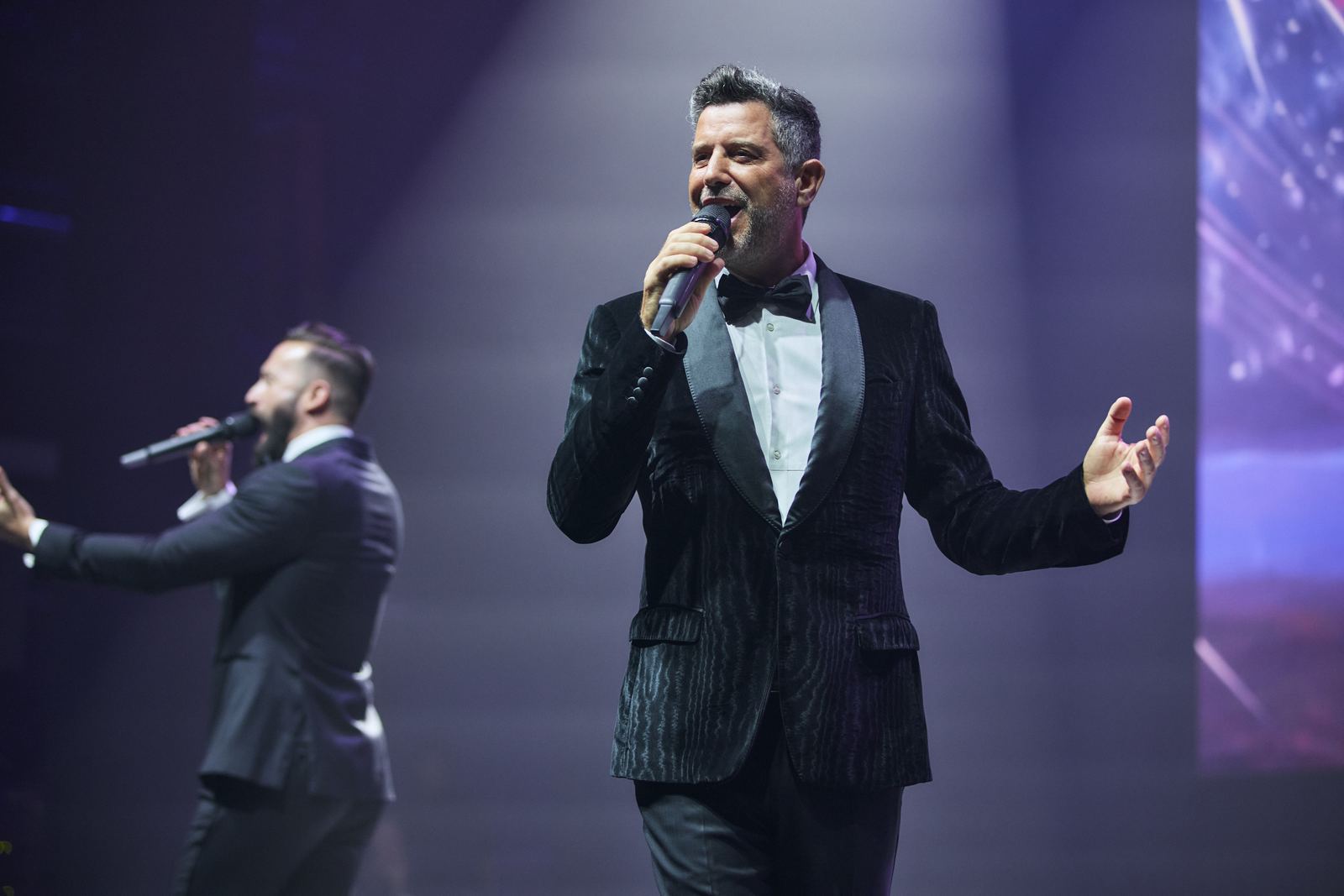 Солист Il Divo поёт, за ним LED-экран.